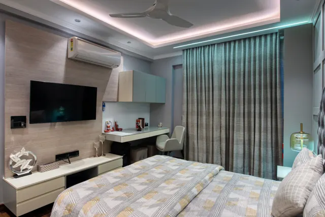 Bedroom with a study desk and wall-mounted TV (photograph)