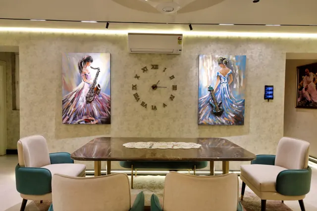 Dining table below framed paintings (photograph)