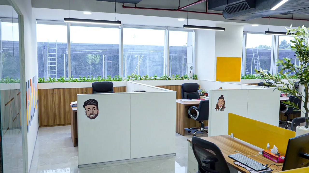 Workstations with yellow partitions and caricature art (photograph)